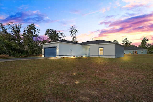 single story home featuring a yard and a garage