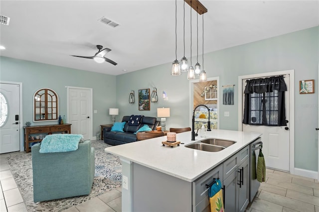 kitchen with sink, dishwasher, decorative light fixtures, gray cabinets, and a kitchen island with sink