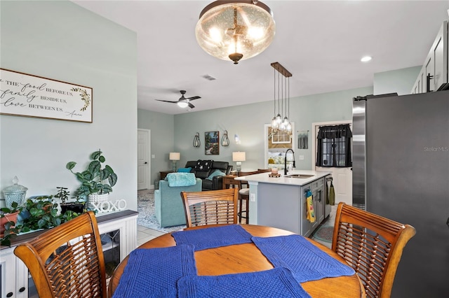 tiled dining room with ceiling fan and sink