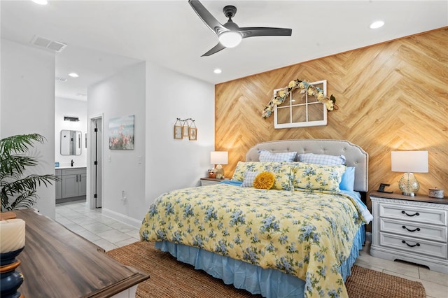 tiled bedroom featuring wood walls, ensuite bathroom, and ceiling fan