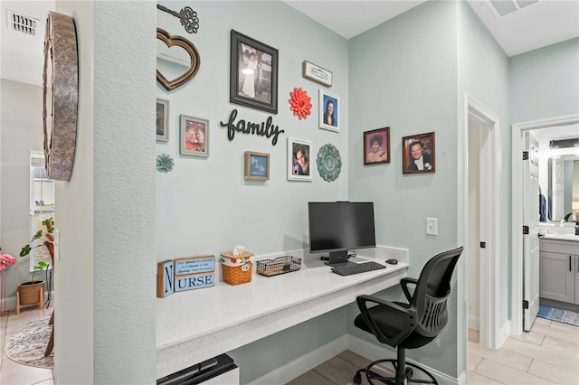 office space with light tile patterned floors and built in desk