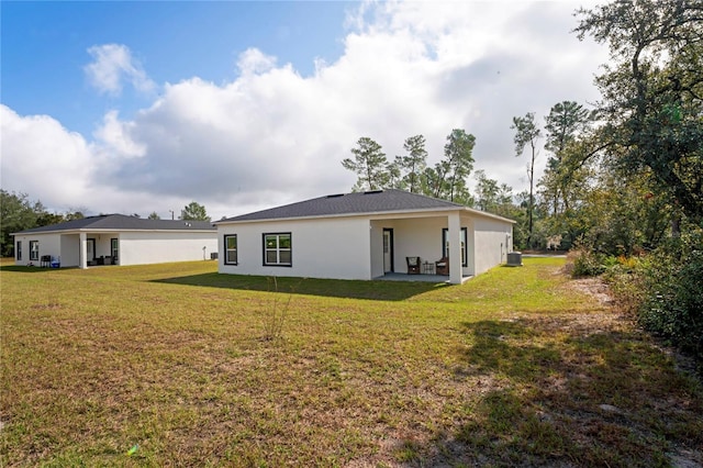 rear view of property with a lawn, a patio area, and central air condition unit