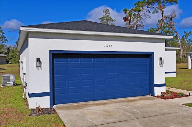 garage featuring central AC unit and a lawn