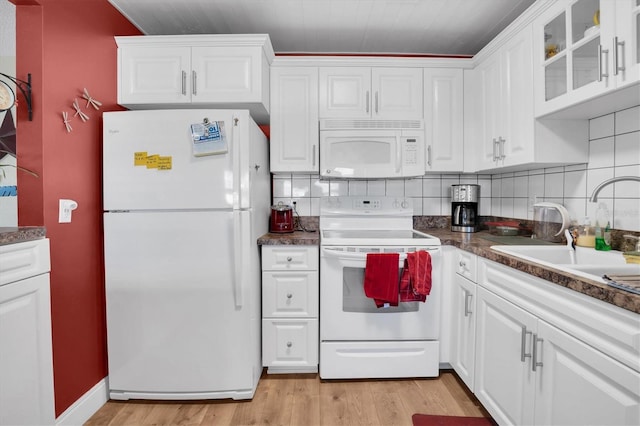 kitchen featuring white appliances, backsplash, white cabinets, sink, and light hardwood / wood-style flooring