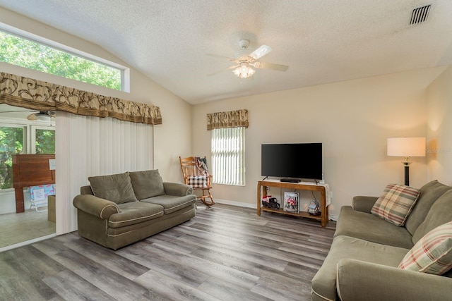 living room featuring wood-type flooring, a textured ceiling, vaulted ceiling, and ceiling fan