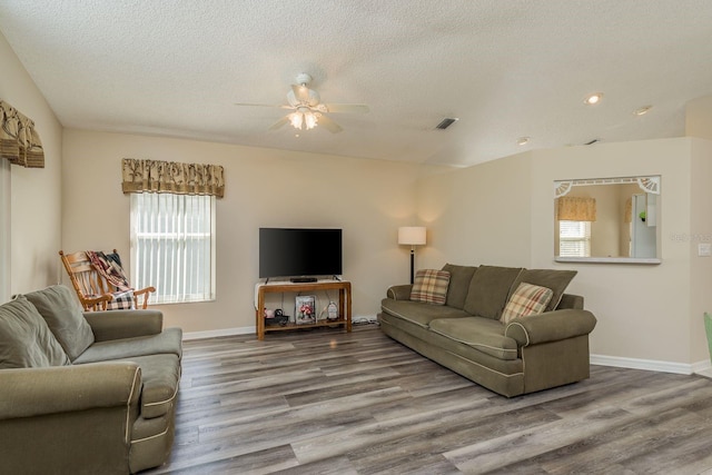 living room with ceiling fan, wood-type flooring, and a textured ceiling