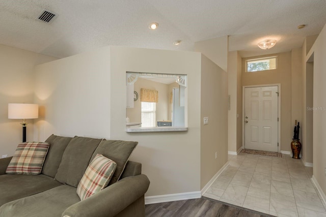 living room featuring a textured ceiling and vaulted ceiling