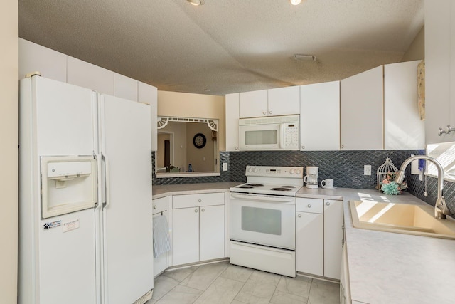 kitchen featuring white appliances, sink, decorative backsplash, a textured ceiling, and white cabinetry