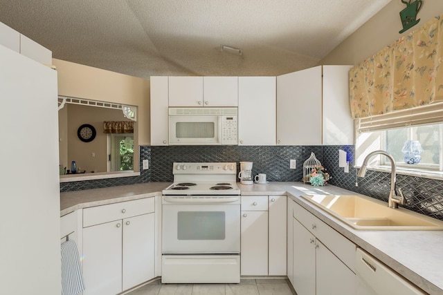 kitchen featuring white cabinetry, sink, backsplash, a textured ceiling, and white appliances