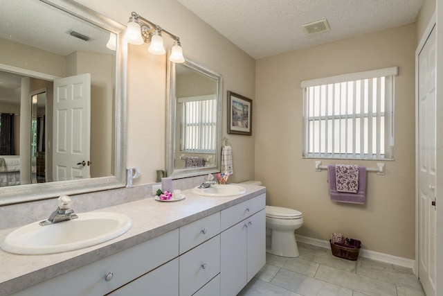 bathroom with vanity, a textured ceiling, and toilet