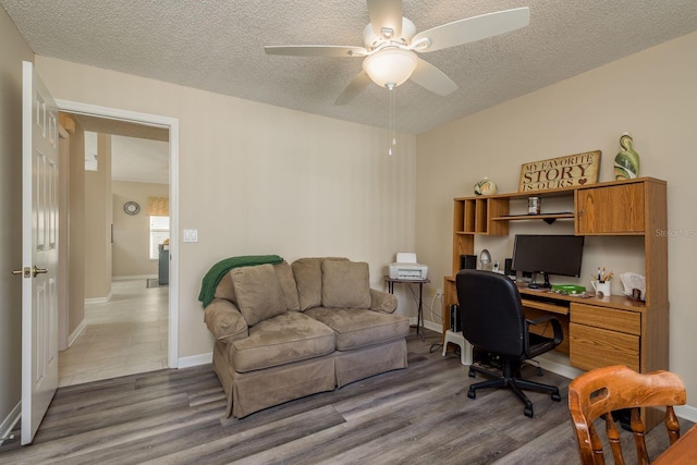 home office featuring ceiling fan, a textured ceiling, and dark hardwood / wood-style flooring