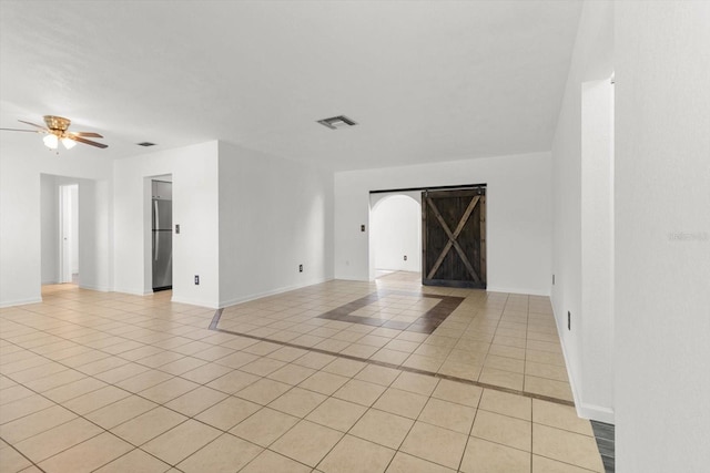 tiled spare room with ceiling fan