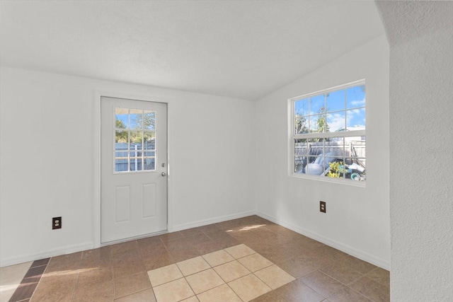 interior space featuring lofted ceiling and light tile patterned floors