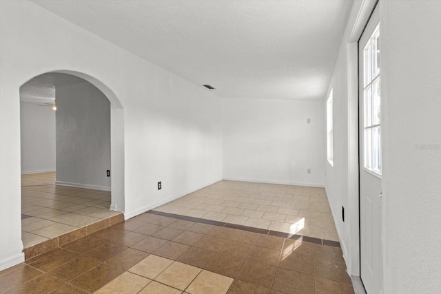 spare room featuring tile patterned flooring and ceiling fan