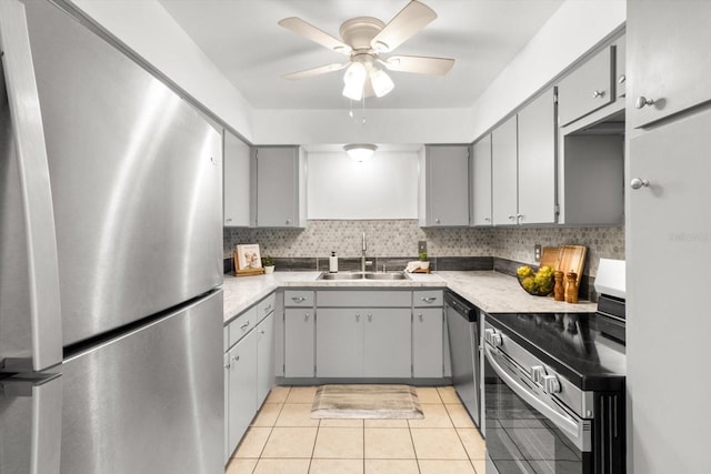 kitchen featuring ceiling fan, sink, stainless steel appliances, gray cabinets, and light tile patterned floors