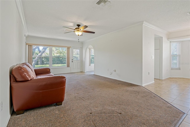 living room with light tile patterned floors, a textured ceiling, ceiling fan, and ornamental molding