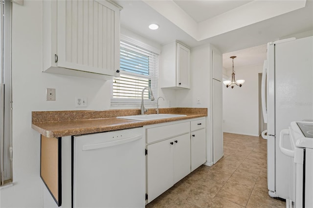 kitchen with white appliances, white cabinetry, and sink