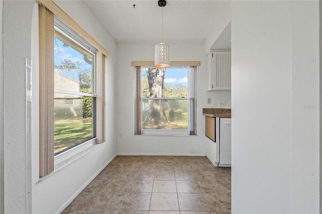 unfurnished dining area featuring light tile patterned flooring and a healthy amount of sunlight