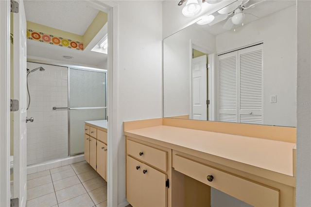 bathroom with ceiling fan, walk in shower, tile patterned flooring, toilet, and vanity