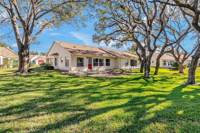 back of property with a patio area and a yard