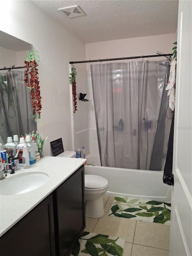 full bathroom with a textured ceiling, vanity, shower / tub combo with curtain, tile patterned flooring, and toilet