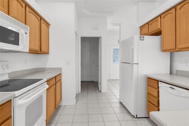 kitchen featuring light tile patterned floors, light countertops, and white appliances