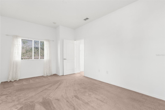 carpeted spare room featuring visible vents and baseboards