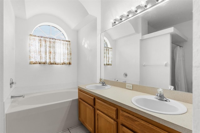 bathroom with tile patterned flooring, vanity, and a bathing tub