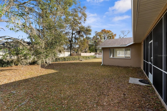 view of yard with fence and a sunroom