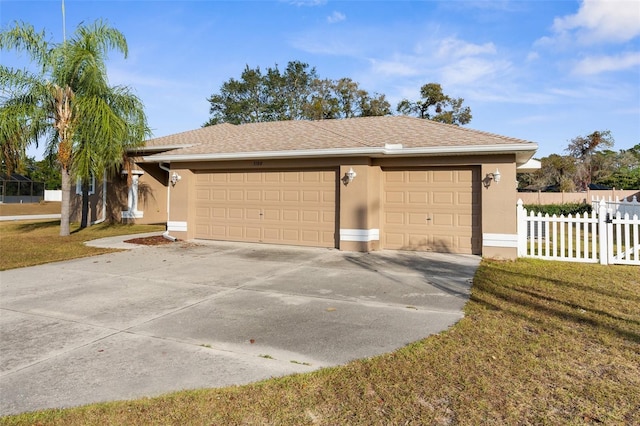 view of front of home featuring concrete driveway, a front lawn, fence, and stucco siding