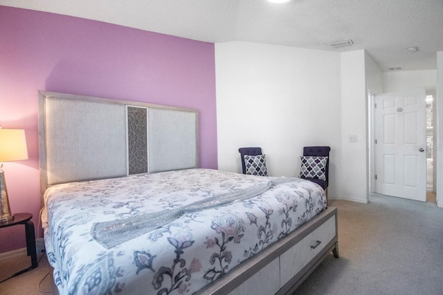 bedroom featuring light carpet and a textured ceiling