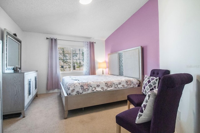 carpeted bedroom with a textured ceiling and vaulted ceiling