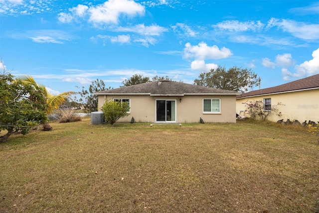 rear view of property featuring a yard and cooling unit