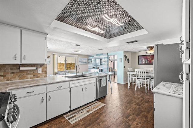 kitchen featuring dark wood-type flooring, white cabinets, sink, tasteful backsplash, and stainless steel appliances