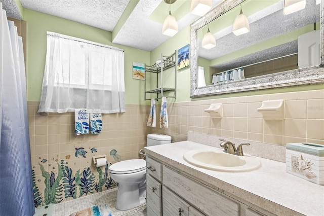 bathroom with vanity, a shower with curtain, toilet, a textured ceiling, and tile walls