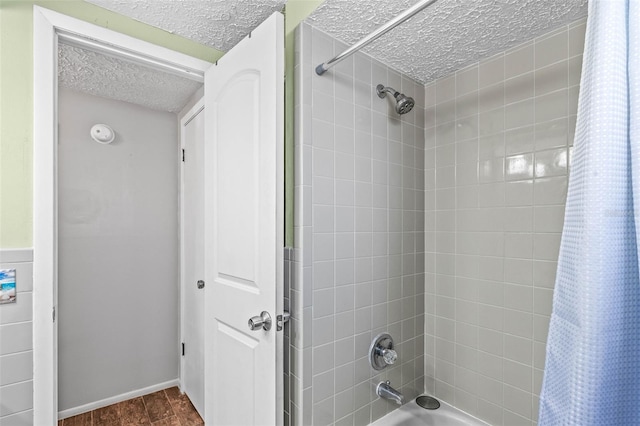 bathroom with shower / tub combo and a textured ceiling