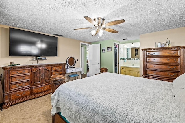 bedroom with a textured ceiling, connected bathroom, a closet, and ceiling fan