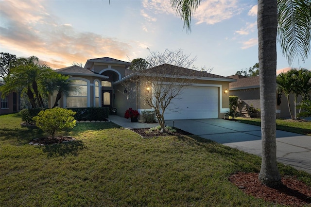 view of front of house featuring a garage and a lawn