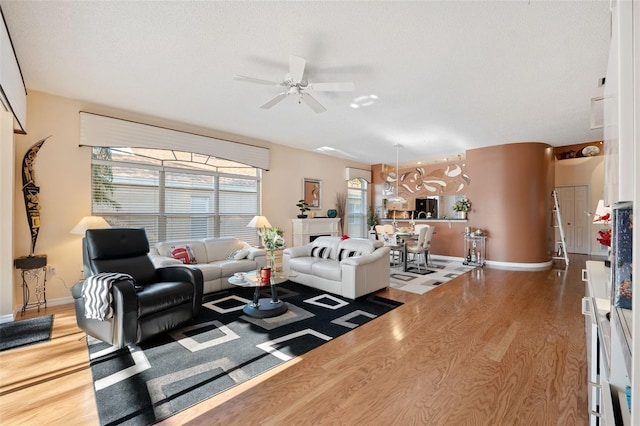 living room featuring hardwood / wood-style flooring, a textured ceiling, and ceiling fan