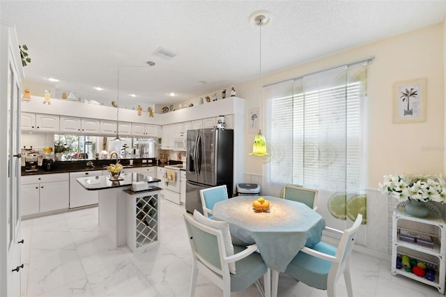 dining area featuring sink and a textured ceiling