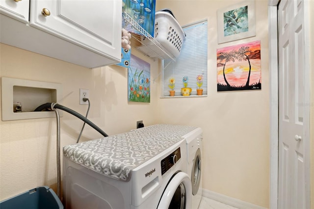 clothes washing area featuring cabinets and independent washer and dryer