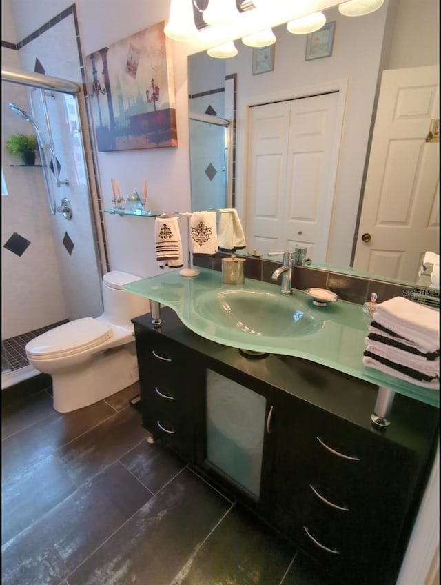 bathroom featuring vanity, toilet, and a shower with shower door