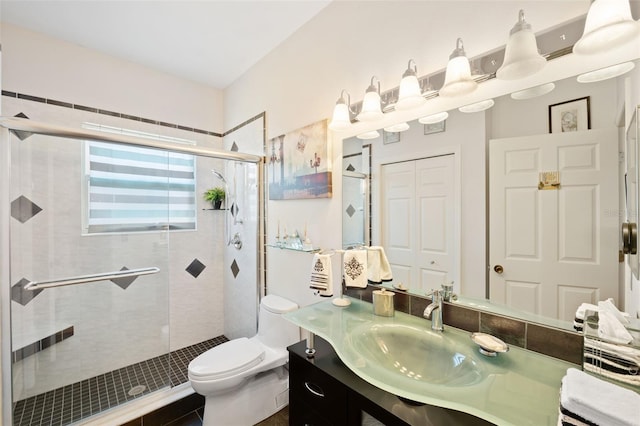 bathroom with vanity, a shower with door, and toilet