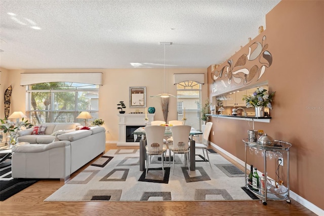 dining area with light hardwood / wood-style floors and a textured ceiling