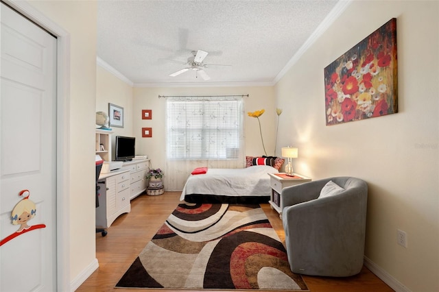 bedroom featuring ornamental molding, ceiling fan, a textured ceiling, and light hardwood / wood-style flooring