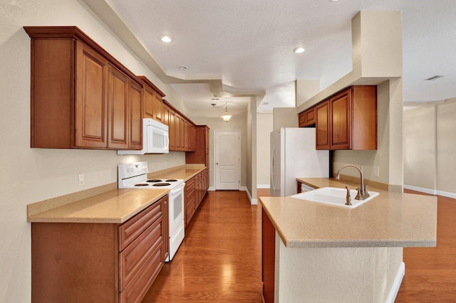 kitchen featuring white appliances, dark hardwood / wood-style floors, sink, and kitchen peninsula