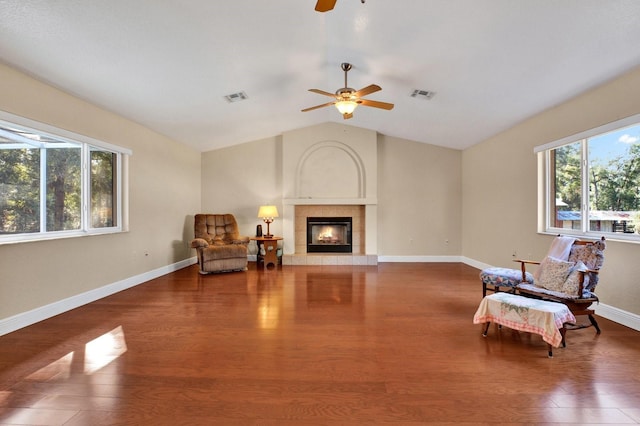 living area featuring ceiling fan, dark hardwood / wood-style flooring, lofted ceiling, and a fireplace