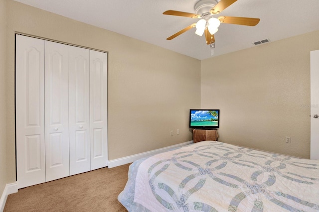 carpeted bedroom with ceiling fan and a closet