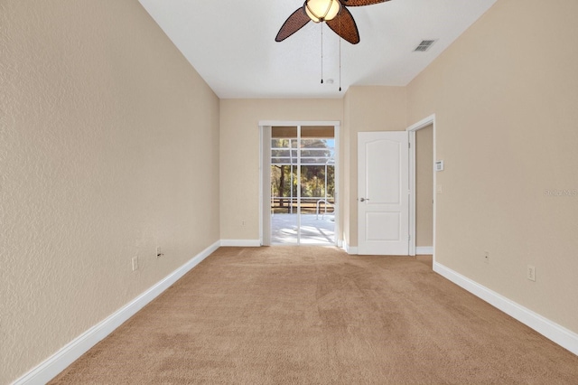 spare room with ceiling fan and light carpet