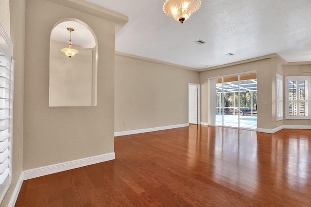 unfurnished room with a textured ceiling and wood-type flooring